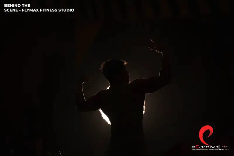 A Flymax athlete holding a dumbbell in the studio